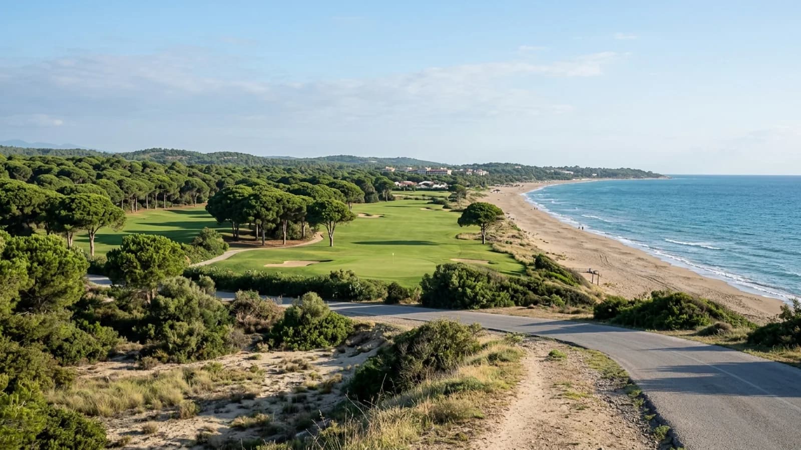 Dennenbossen en een groen golflandschap in Belek, gelegen naast een lang zandstrand.